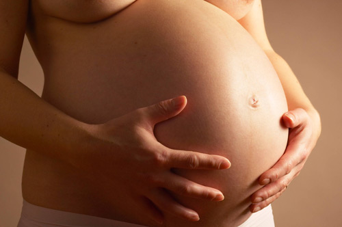 Pregnant_woman_holding_her_bel